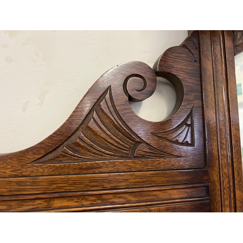 1445 - An Edwardian dark oak mirror backed side board with decorative carved columns and panelled detail. B... 