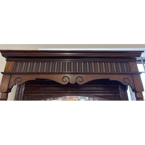 1445 - An Edwardian dark oak mirror backed side board with decorative carved columns and panelled detail. B... 