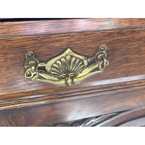 1445 - An Edwardian dark oak mirror backed side board with decorative carved columns and panelled detail. B... 