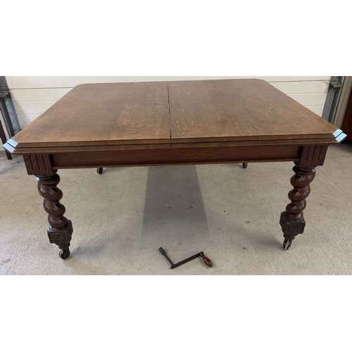 1447 - An antique dark oak wind out, extending dining table with barley twist legs raised on square shaped ... 