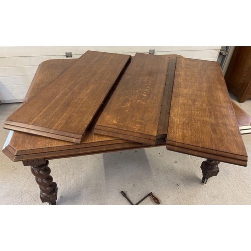 1447 - An antique dark oak wind out, extending dining table with barley twist legs raised on square shaped ... 