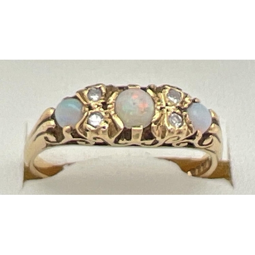 1077 - A Victorian style 18ct gold opal and diamond gypsy dress ring with pierced scroll design mount. Ring... 