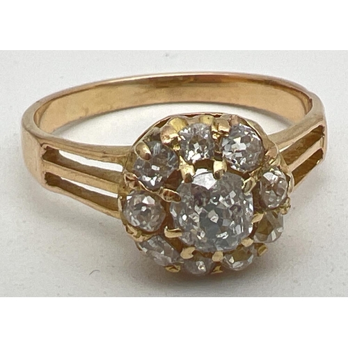 1083 - A vintage yellow gold 1ct diamond halo set cluster ring. Central round cut stone surrounded by 9 var...