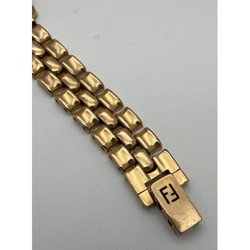 1160 - A ladies 810-L wristwatch by Fendi. Gold tone bracelet strap with Fendi logo to clasp. Gold tone fac... 