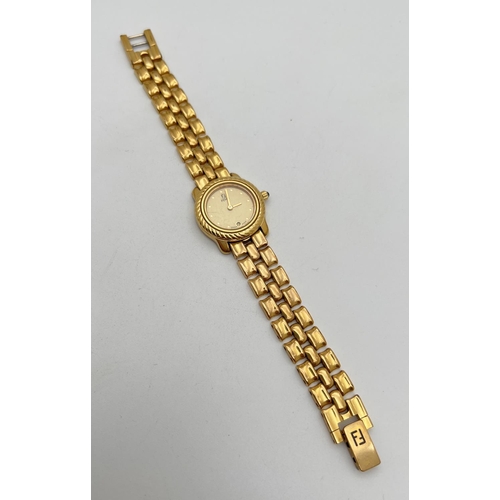 1160 - A ladies 810-L wristwatch by Fendi. Gold tone bracelet strap with Fendi logo to clasp. Gold tone fac... 