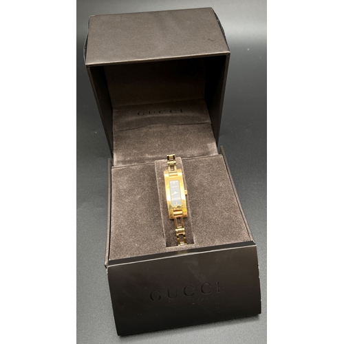 1151 - A boxed ladies 3900L wristwatch by Gucci. Gold tone stainless steel strap and case. Black face with ... 