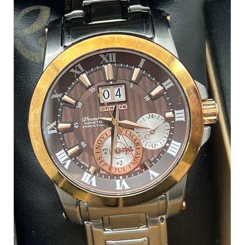 A boxed special edition Novak Djokovic Seiko 7D56 Kinetic Perpetual chronograph wristwatch. Stainless steel strap and case with gold tone bezel. Metallic brown face with bronze hour markers and hands. Seconds hand and date function. 10 bar water resistant. With original paperwork. In working order.