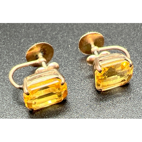 1005 - A pair of yellow metal screw back earrings each set with an emerald cut citrine stone. Unmarked but ... 