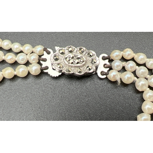 1067 - A vintage 3 row string of graduated real cultured pearls with marcasite set fish hook clasp. In a pe... 