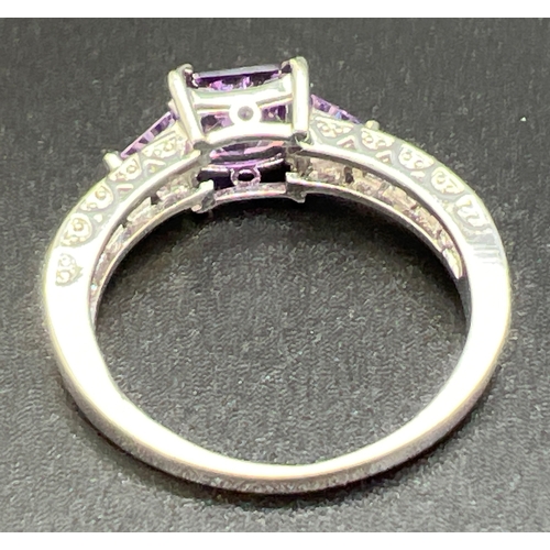 1070 - A modern white metal cocktail ring of Art Deco design, set with purple coloured stones. Ring size U.