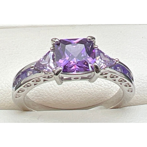 1070 - A modern white metal cocktail ring of Art Deco design, set with purple coloured stones. Ring size U.