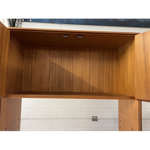 1407 - A mid century G Plan wall unit with sliding door cupboard to base and 2 door cupboard to top. With 2... 