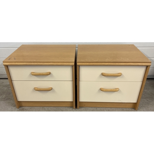 1417 - A pair of vintage Stag 2 drawer bedside cabinets in light natural wood and cream coloured finish. Ea... 