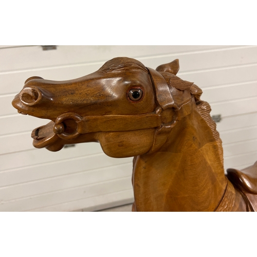 A vintage hand carved hardwood carousel style glider rocking horse. Saddle and bridle carved in wood