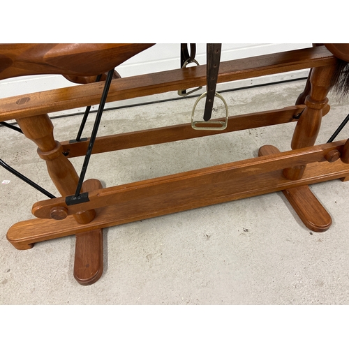 A vintage hand carved hardwood carousel style glider rocking horse. Saddle and bridle carved in wood