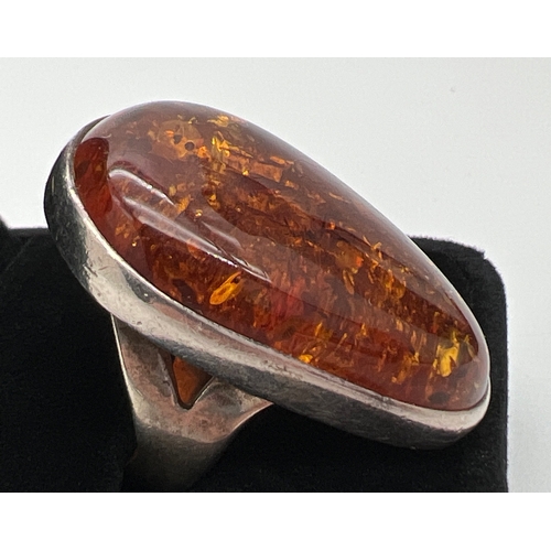 1016 - A very large cognac amber set silver dress ring. Stamped 925 to underside. Ring size P½. Amber appro... 