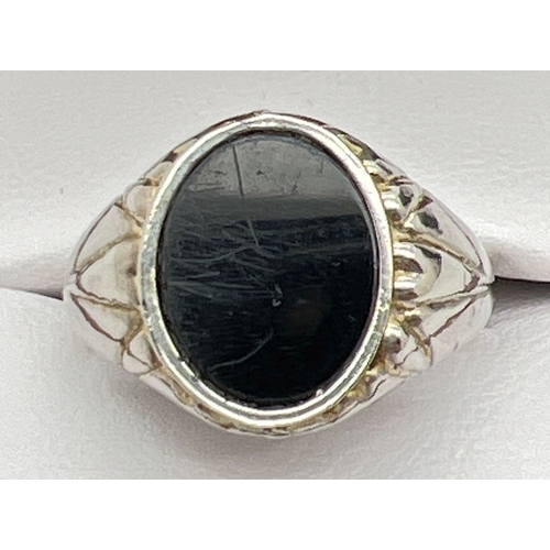 1017 - A vintage onyx set signet style ring with channelled design mount. Ring size W.