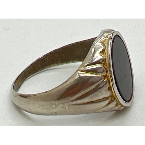 1017 - A vintage onyx set signet style ring with channelled design mount. Ring size W.