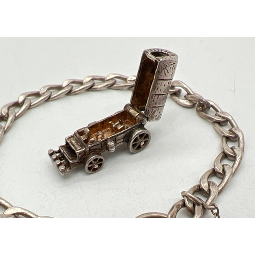 1032 - A vintage silver curb chain charms bracelet with padlock and safety chain together with a white meta... 