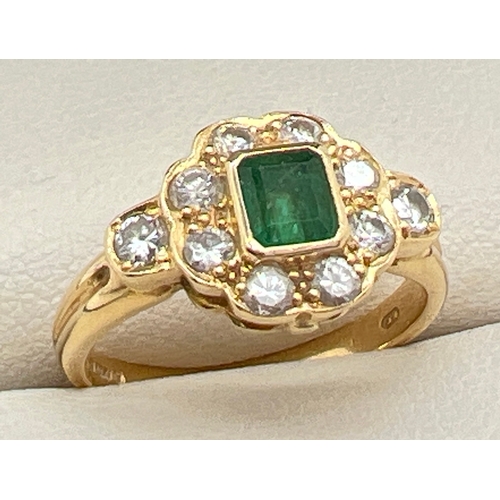 1039 - An 18ct gold diamond and emerald dress ring. Central square cut emerald surrounded by 8 round cut di... 
