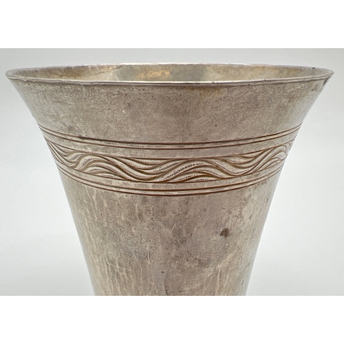 1223 - An Omar Ramsden Arts & Crafts silver beaker of hammered conical form with rose design rim to base. F... 