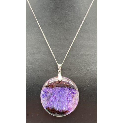 1005 - A large round natural stone pendant in purple and blue tones, possibly Blue John. On an 18 inch fine... 