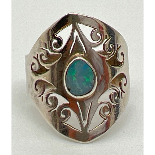 1058 - A modern design silver dress ring with pierced work scroll detail and a central bezel set opal. Silv... 