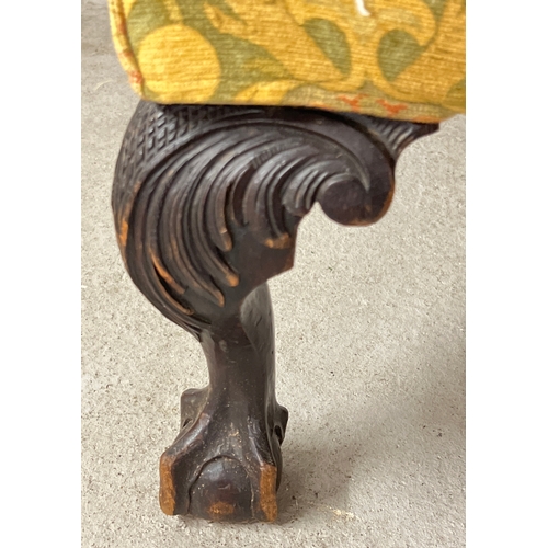 1414 - An antique dark wood wing back chair with ball and claw carved front feet and green, yellow and oran... 