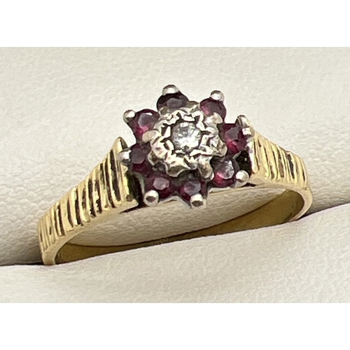 62 - A vintage 9ct gold, garnet and diamond dress ring. Small central round cut diamond surrounded by 8 s... 