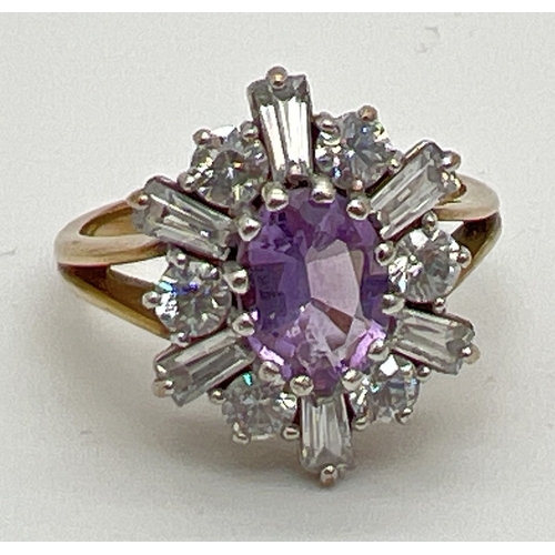 64 - A 9ct gold, amethyst and clear stone decorative dress ring. A central oval cut amethyst surrounded b... 