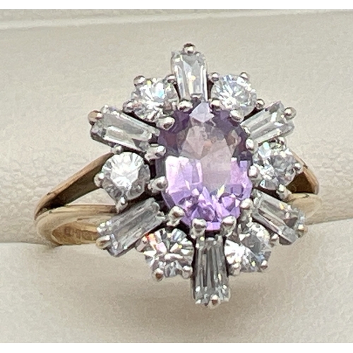 64 - A 9ct gold, amethyst and clear stone decorative dress ring. A central oval cut amethyst surrounded b... 