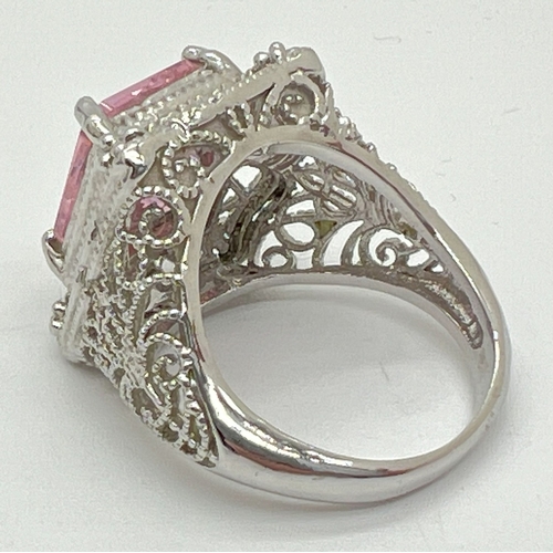 1008 - A large silver cocktail ring with decorative filigree style mount, set with a large pale pink square... 