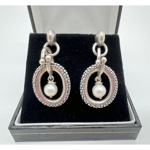 1017 - A pair of silver, 14ct gold and pearl drop earrings by Michael Dawkins. Round white single pearl sus... 