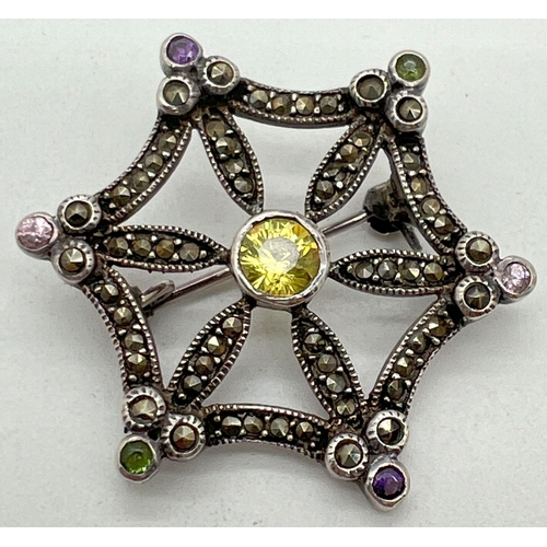 1027 - A vintage silver brooch modelled as a star/spiders web, set with round cut coloured stones and marca... 