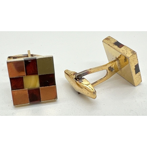 1039 - A pair of gold on silver chequerboard design cufflinks set with squares of honey & cognac amber. Eac... 
