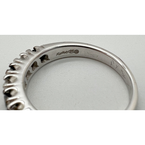 1042 - A 9ct white gold 7 stone blue and white diamond eternity ring by Kallati. Makers name and gold mark ... 