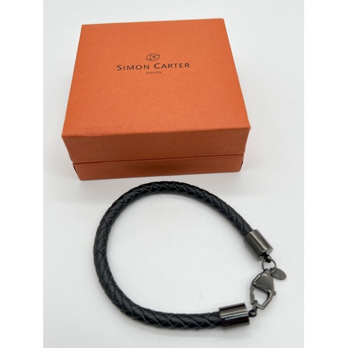 1047 - A boxed Simon Carter, London, men's plaited black leather bracelet with black metal lobster clasp, f... 