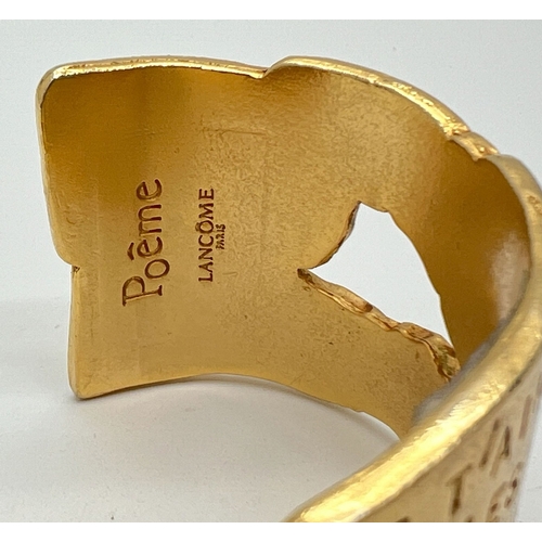 1050 - A gold plated Lancôme Poeme bangle inscribed with the poem Ode to love. Made for the launch of the p... 