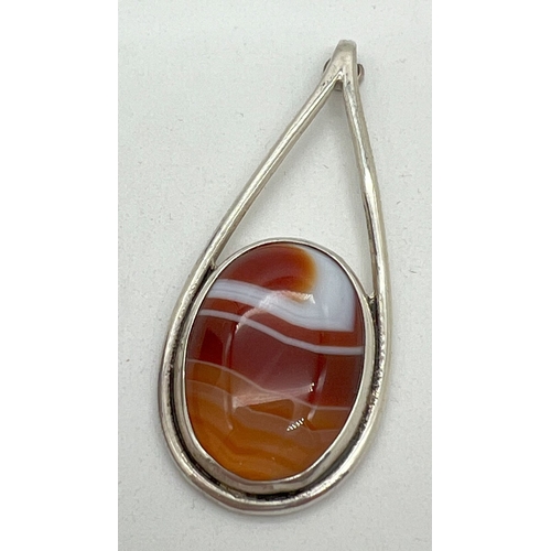 1067 - A vintage contemporary design silver drop pendant set with an oval of red and cream agate. Hallmarke... 