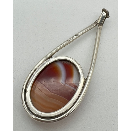 1067 - A vintage contemporary design silver drop pendant set with an oval of red and cream agate. Hallmarke... 