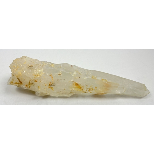 1304 - A large clear quartz natural laser wand with orange, brown and black inclusions. Areas of small clus... 