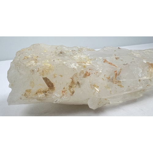 1304 - A large clear quartz natural laser wand with orange, brown and black inclusions. Areas of small clus... 