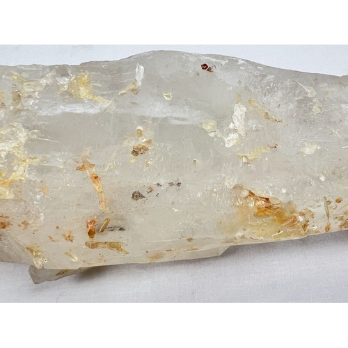 1304 - A large clear quartz natural laser wand with orange, brown and black inclusions. Areas of small clus... 