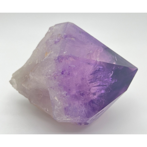 1307 - A large natural amethyst point. Rainbow inclusions visible. Approx. 9cm x 16cm.