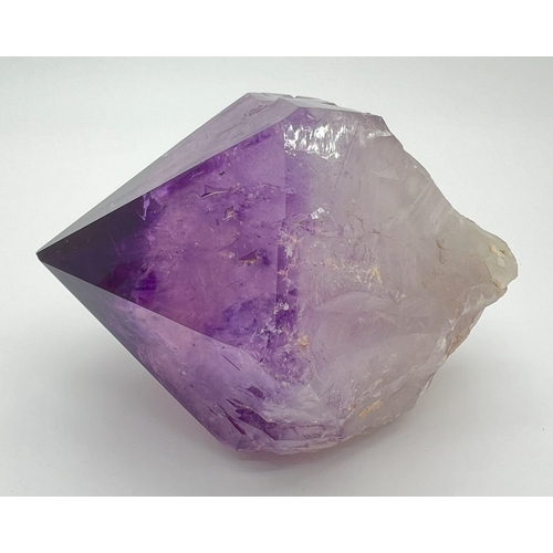 1307 - A large natural amethyst point. Rainbow inclusions visible. Approx. 9cm x 16cm.