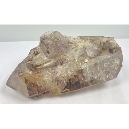 1309 - A large 7.8 kg double terminated smoked quartz crystal point with hematite inclusions and multiple c... 