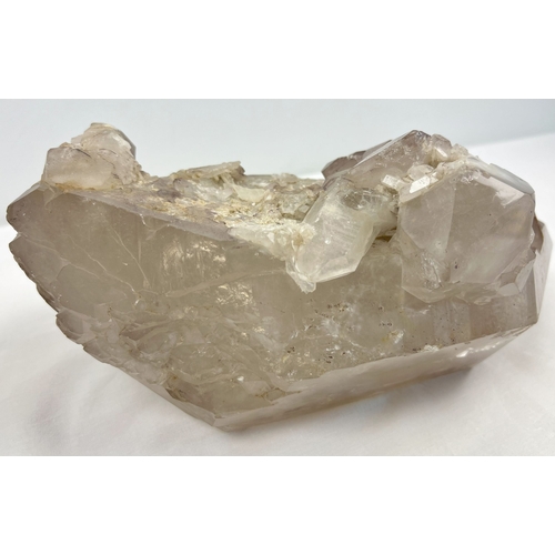 1309 - A large 7.8 kg double terminated smoked quartz crystal point with hematite inclusions and multiple c... 