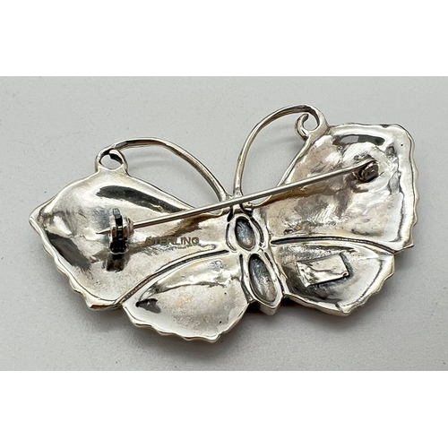 1155 - A green enamelled silver butterfly brooch, stamped sterling to reverse. Approx. 5.5cm wide.