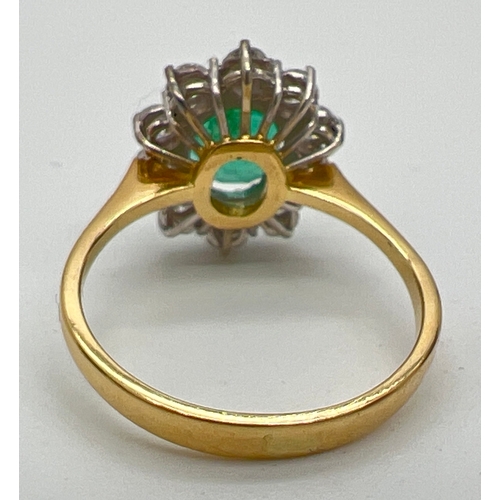 1157 - An 18ct gold, emerald and diamond cluster ring. A central oval cut emerald surrounded by 10 round cu... 