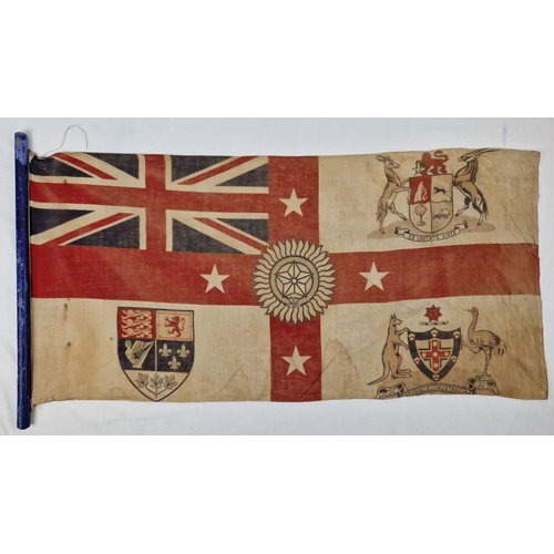 A vintage British Australian Empire flag on a cut down modern wooden pole. Depicting Unions flag, 1 large and 4 smaller 7 point stars and a single 5 point star. Post 1909, approx. 42cm x 83cm.